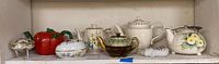 Full set of five teapots and three china pieces on shelf