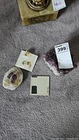 Lot items including amethyst bowl, square mirrors, and glass dolphin figurines arranged on carpet.