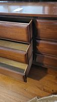 Left side of dresser showing two drawers open and lower drawers partially open