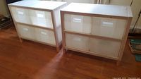 Two wooden framed storage bin units with four translucent corrugated plastic drawers each on hardwood floor