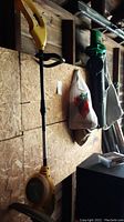 Yellow WeedEater RT112C string trimmer hanging in garage, showing full length and handle