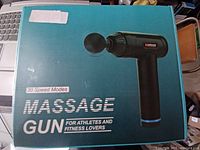 Photo of packaged massage gun box showing product image and text indicating 30 speed modes for athletes and fitness lovers.