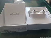 Opened box showing AirPods Pro in charging case alongside packaging insert