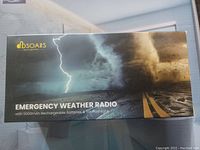 Box front showing DBSOARS Emergency Weather Radio with 5000mAh rechargeable batteries and 3W flashlight