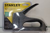 Stanley Light Duty Staple Gun in original packaging showing front view with branding and staple remover feature.
