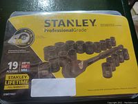 Photo of packaged Stanley Professional Grade 19 piece socket set with yellow and black branded box showing the ratchet and sockets