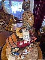 Photo showing the Old West carriage model with cowboy figure broken and separate from the carriage, along with the cat statue visible in background.