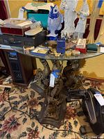 Front view of round glass top table on dragon base with surrounding items