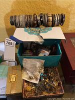 Wood and metal bracelet stand holding approximately 20 assorted bangles in various materials and finishes