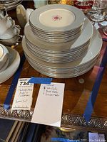 Stack of 23 Flintridge china plates with a central pink rose floral pattern and silver rim. Includes salad, bread, and dinner plates.