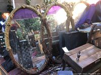 Three-panel gilded mirror with ornate frames, showing overall condition and damage.