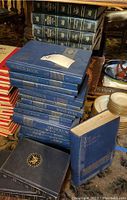 Stack of blue hardcover World Book Encyclopedia volumes, some with visible scratches and a sticker on top volume.