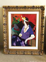 Full view of framed serigraph showing ornate gold frame, linen matting, and the full image of the seated woman