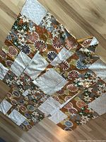 Full view of the kimono laid flat showing the patterned silk fabric with floral and geometric designs.