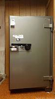 Full view of the gray Donovan stand up safe, showing front door with combination dial and key lock assembly.
