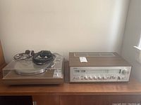 Receiver, turntable and black headphones side by side