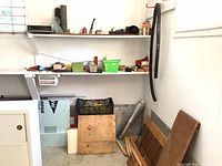 Shelves and floor area showing scattered wood pieces, ropes, and other small items.