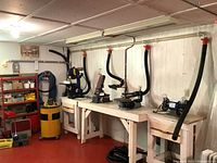 Wide view of woodworking station with dust suction system including Shop-Vac Model 850 vacuum, pipes, hoses, and workbenches.