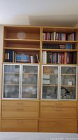 Front view of the full Ikea Galant combination bookcase showing open shelving, glass door cabinets, and drawers.