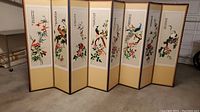 Folding screen fully opened showing embroidered birds, flowers, and bamboo with calligraphy on reverse panels.