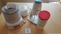 Cuisinart ice cream maker, ice shaver, kettle shown together on a table with power cords visible.