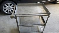 Metal rolling cart showing top and bottom shelves with no items.