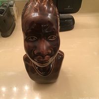 Front view of the African bust sculpture showing detailed facial features and glossy finish.