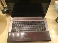 Open Asus laptop showing keyboard and palm rest area with minor wear.