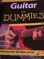 Photo of the front cover of Guitar For Dummies book 2nd edition, showing a close-up of hands playing a guitar.