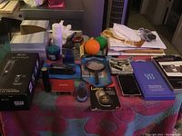 Photo showing wide assortment of items on a table including trimmer box, phone, containers, and accessories