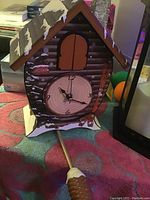 Cuckoo clock showing front with clock face and pendulum