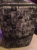 Front view of the hard-shell rolling suitcase with a black and white collage pattern featuring Michelle Obama images.