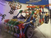 Photo of a detailed K'nex built vehicle model using plastic rods and connectors in various colors including white, blue, green, and red.