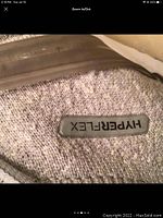 Close-up photo showing the 'Hyper-Flex' branding on gray knit fabric of the shoe upper.