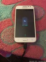 Samsung Galaxy Core smartphone powered on showing battery charging at 0%