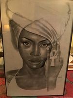 Straight-on photo of the signed black and white portrait print showing a woman with a head wrap holding an ankh symbol, signed in lower right corner.