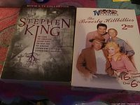 Photo showing two DVD box sets: Stephen King Movie & TV Collection and The Beverly Hillbillies 2 DVD set with cover images.