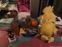 Overview of all items in the toy lot including plush, figurines, balls, and boxed kit