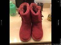 Front view of the red women's Koolaburra boots showing their plush interior and suede exterior.