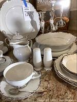 Full set of Bristol China dinnerware pieces with white porcelain and silver edges shown on countertop