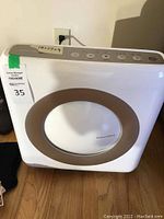 Front view of Coway air purifier showing circular air intake/outlet area and brand name.