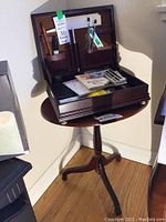 Open wooden desk organizer with various office supplies on round wooden end table