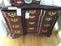 Front view of dark wood Ethan Allen dresser with multiple drawers and brass handles, showing overall condition and style.