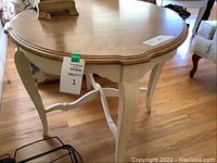 Side view of the Ethan Allen wooden side table showing natural wood top and cream curved legs with decorative stretcher.