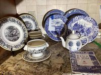 Italian blue and white china plates in front, Spode blue and white plates and teapot in back with a Blue Room Collection booklet.