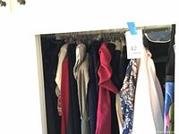 Closet view of assorted ladies clothing items size small on hangers showing variety of colors and textures