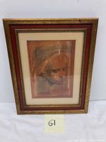 Front view of framed portrait in gold and red wooden frame with mat and glass, showing child’s portrait.