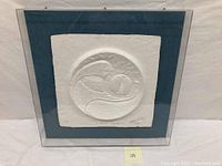 Framed pressed paper art featuring embossed animal design, showing the full piece against a neutral background.