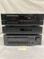 Front view of stacked Denon DRM-555 cassette tape deck on top, Yamaha CDX-470 CD player in the middle, and Sony STR-D365 receiver at bottom, showing front panel controls and displays.