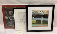 Three framed art lithographs displayed side by side, showing a red-framed abstract psychedelic print, a black and white cartoon, and a colorful abstract print